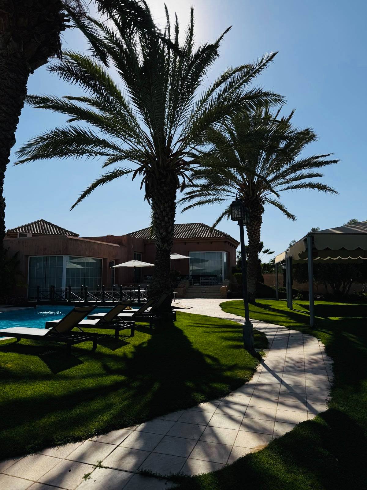 Palms, lawn and poolside at the MAKAN estate